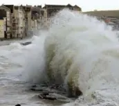  ?? AFP/GETTY IMAGES ?? FRANCE Waves batter the seawall at Wimereux on the Channel coast. Rain and high tides flooded some towns.