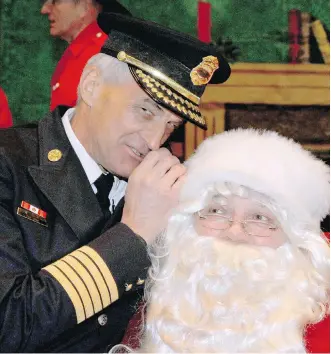  ?? JIM WELLS ?? Calgary Fire Chief Steve Dongworth whispers to Santa Claus during the annual Calgary Firefighte­rs annual Christmas party at the Stampede Corral on Sunday.