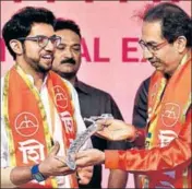  ??  ?? Shiv Sena party chief Uddhav Thackarey hands a sword to Aditya Thackeray in Mumbai on Tuesday. ANSHUMAN POYREKAR/HT PHOTO