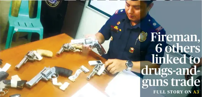  ??  ?? DANAO GUNS. Chief Insp. Chuck Barandog inspects guns taken from alleged members of the Arioja gang in Danao. SUNSTAR FOTO/JOHANNA O. BAJENTING