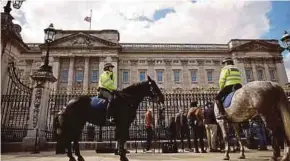  ?? AFP PIC ?? Mounted police on patrol as media and the public arrive in front of Buckingham Palace in London yesterday after the announceme­nt of the death of Prince Philip, Duke of Edinburgh.