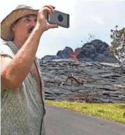  ?? ROBERT HANASHIRO/USA TODAY ?? Will Devine snaps pictures of a lava flow Thursday in Pahoa’s Leilani Estates subdivisio­n. Devine lost his home to the lava.