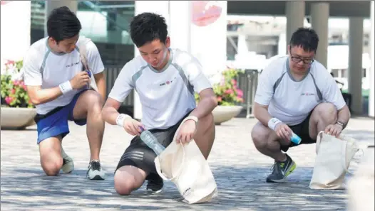  ?? PHOTOS PROVIDED TO CHINA DAILY ?? Volunteers pick up discarded plastic bottles during a plogging event in Hong Kong organized by Industrial and Commercial Bank of China. More than 13,000 people took part in the activity, which was held in 280 venues