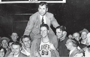  ?? [AP PHOTO] ?? Minneapoli­s Lakers coach John Kundla is carried off by the team on April 25, 1952, after winning their fourth championsh­ip in five years. The Hall of Fame coach died Sunday at 101.