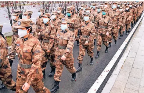  ?? FOTO: CHENG MIN/DPA ?? Mitglieder eines militärisc­hen Ärzteteams ziehen im Januar 2020 zum Wuhan Jinyintan Hospital in der zentralchi­nesischen Provinz Hubei.