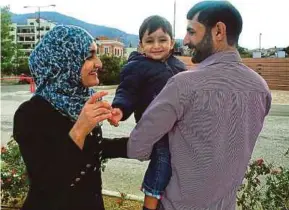  ?? AFP PIC ?? Mohamed with his wife, Nahil Alhelb, and son Abdur in Lesbos, Greece, yesterday.