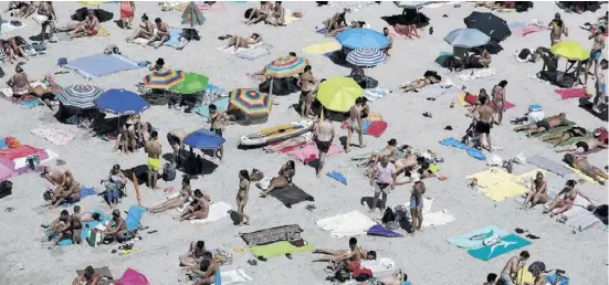  ?? Foto: dpa ?? Urlauber nehmen ein Sonnenbad am Strand. Trotz Inflation lassen sich die Spanier die Ferien nicht nehmen.