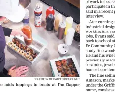  ?? COURTESY OF DAPPER DOUGHNUT ?? An employee adds toppings to treats at The Dapper Doughnut.