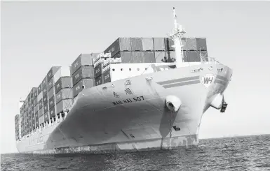  ?? COLEY BROWN/THE NEW YORK TIMES ?? One container ship among many anchored recently outside the Port of Los Angeles. Massive vessels now dominate global shipping: 133 ships that can carry 18,000 or more containers are now in service, and another 53 are on order.