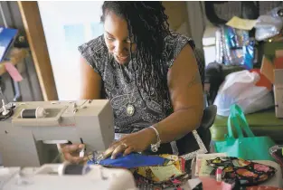  ?? KRISTEN ZEIS/STAFF ?? Dena Townsend sews a mask, using a custom pattern designed to fit comfortabl­y on the wearer’s face for long periods, in a studio out of her home in Chesapeake. The masks have filters and are machine washable.