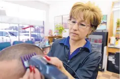  ??  ?? Carmen Baca, owner of Carmen’s Cuts, gives a trim to fellow Chihuahua native Adan Lopez. Her family emigrated from Chihuahua “looking for a better life,” she says.