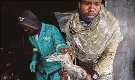  ?? AFP PIC ?? Volunteers taking part in a clean-up operation at the looted Bara Mall in Soweto, South Africa, on Thursday.