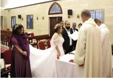  ?? —AFP photos ?? Maya Khadra and Rakan Ghossein stand in front of a priest during their wedding at the church Our Lady Of Assistance in the village of Shemlan south of Beirut.