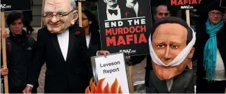  ?? ?? A protest group campaignin­g against the political dominance of Rupert Murdoch stage a mock burning of a copy of the Leveson Report into press culture and ethics after its release in 2012.