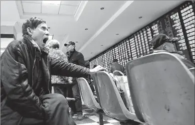  ?? XING QU / FOR CHINA DAILY ?? An investor appears unimpresse­d by the yawning gap between his expectatio­ns and actual stock prices at a brokerage in Nanjing, Jiangsu province, on Dec 19, when the Shanghai Composite Index closed almost flat.