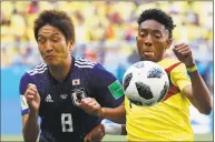  ?? Eugene Hoshiko / Associated Press ?? Japan’s Genki Haraguchi, left, and Colombia’s Johan Mojica battle for the ball during Tuesday’s contest. Japan won 2-1.