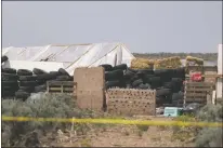  ?? Jesse Moya ?? Broken glass tops a mud and glass bottle wall under constructi­on at a remote compound near the Colorado border where the remains of a missing Georgia boy were found Monday (Aug. 6) and where 11 children were taken into protective custody. Court documents allege one of the children was trained to use a weapon for future school shootings.