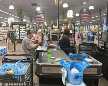  ?? Pittsburgh Post-Gazette ?? Ronda Sheran, of Etna, pay for groceries at the Waterworks Market District Giant Eagle near Aspinwall. According to the USDA Economic Research Service, overall food prices are up 2.2% from May 2020.