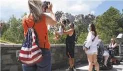  ?? Scott Olson / Getty Images ?? Tourists visit Mount Rushmore National Monument in South Dakota on Wednesday, ahead of President Trump’s visit and fireworks.