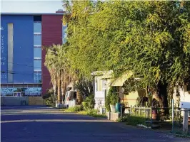  ?? AP PHOTO ?? Grand Canyon University’s Verde Apartments rise above the Periwinkle Mobile Home Park on April 11 in Phoenix. Residents of the park are facing an eviction deadline of May 28 due to the private university’s plan to redevelop the land for student housing.