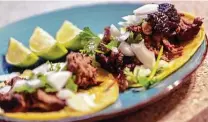  ?? William Luther / Staff photograph­er ?? Beef cheeks cooked in the smoker — then topped with lime, onions and cilantro — make tender and tasty tacos.