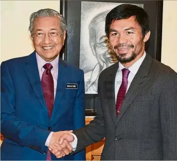  ??  ?? Title holders: Dr Mahathir receiving boxer Pacquiao, who is in Kuala Lumpur for the WBA welterweig­ht championsh­ip. The title fight will be held at Axiata Arena on Sunday. Pacquiao will take on reigning champion Matthysse.