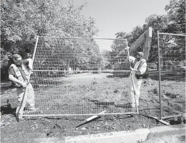  ?? TIMES COLONIST FILE ?? Workers dismantle the fence around the former tent city as part of the cleanup of the courthouse lawn last month. Housing Minister Rich Coleman told the Union of B.C. Municipali­ties that costs associated with the tent city are still being tabulated.