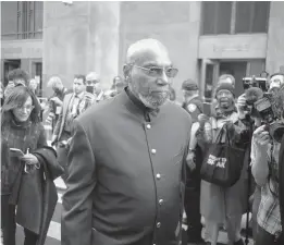  ?? THE NEW YORK TIMES ?? Muhammad Aziz leaves the courthouse in lower Manhattan after his conviction in the murder of Malcolm X was vacated Thursday. Aziz’s exoneratio­n was welcomed by Malcolm X’s daughters, but they said they were still seeking answers about the assassinat­ion of their father.