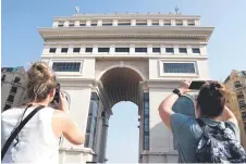  ?? ?? Tourists taking pictures of the Elysee Commercial Centre building in the Paris-style developmen­t along the Bassac river.