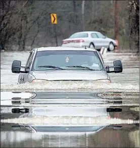  ?? Arkansas Democrat-Gazette/MITCHELL PE MASILUN ?? Nick Jackson of North Little Rock plows through high water Friday near Rixey and Barnder roads in North Little Rock. More rain is forecast today for much of Arkansas.