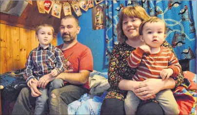  ?? NIKKI SULLIVAN/CAPE BRETON POST ?? Emmett Cormier, 5, sits on the lap of his his dad, Justin Cormier’s, on the bed in his bedroom in his Sydney Mines home. Next to him, his mother, Alex Cormier, holds his one-year-old brother, Samuel Cormier. Emmett has autism and Alex has just released...