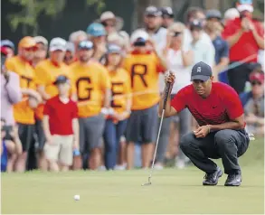  ?? MIKE CARLSON/THE ASSOCIATED PRESS ?? Tiger Woods lines up his putt on the 13th hole on Sunday during the Valspar Championsh­ip in Palm Harbor, Fla. Woods finished a stroke back of winner Paul Casey.