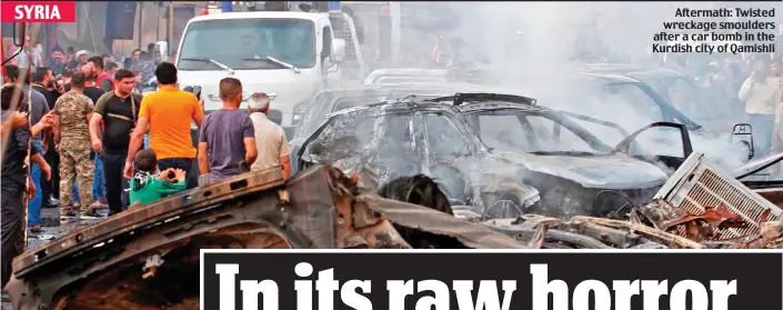  ??  ?? Aftermath: Twisted wreckage smoulders after a car bomb in the Kurdish city of Qamishli