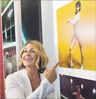  ?? CP PHOTO ?? Montreal 1976 Olympics gymnastics champion Nadia Comaneci points to a photograph of her competing as she tours an exhibit marking the 40th anniversar­y of the Games.