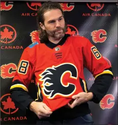  ?? CP PHOTO LARRY MACDOUGAL ?? Jaromir Jagr puts on a team jersey as he is introduced as the newest Calgary Flames player at a press conference in Calgary, Alta., on Wednesday.