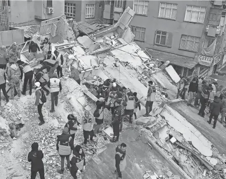  ?? STR/AFP VIA GETTY IMAGES ?? Rescuers search for survivors in the rubble in Sanliurfa, Turkey, on Monday after a 7.8 magnitude earthquake struck the country’s southeast. In Turkey alone, more than 5,600 buildings were destroyed, authoritie­s said.