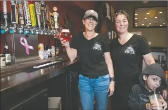  ?? NEWS-SENTINEL PHOTOGRAPH­S BY BEA AHBECK ?? Marci Jones and Shae Porter, owner of Porter’s Pub, with their son Brendon Porter-Jones, 4, at the Lodi restaurant on Thursday. Jones has been undergoing treatment for breast cancer.