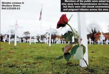  ?? Wooden crosses in Wooburn Green. Ref:133165-13 ?? Members of the public were asked to stay away from Remembranc­e services, but there were still closed ceremonies and poignant tributes across the area.