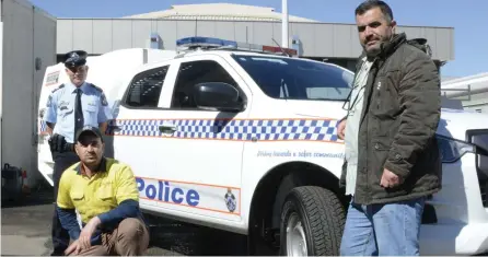  ??  ?? Yazidi refugees (from left) Saad Adbi and Sulaiman Iylas run a business cleaning police vehicles at the Toowoomba Police Station. Officer-in-Charge Tony Neumann said the program helped break down barriers between the refugee community and the police.