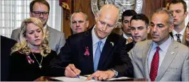  ?? MARK WALLHEISER / ASSOCIATED PRESS ?? Andrew Pollack (right) hasn’t stopped his crusade to protect students after his work earned him a spot beside Gov. Rick Scott in March while Scott signed a law boosting school safety and restrictin­g access to guns.