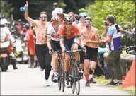  ?? Anne-Christine Poujoulat / AFP / Getty Images ?? Belgium’s Dylan Teuns, front, cycles followed by Italy’s Giulio Ciccone as fans run beside them before the finish line of the sixth stage of the 106th edition of the Tour de France on Thursday.