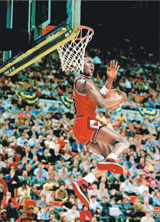  ?? Andrew D. Bernstein NBAE / Getty Images ?? MICHAEL JORDAN wore a black-and-red version of the new Air Jordan I in the 1985 All-Star slam-dunk contest, capturing the world’s attention.