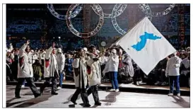  ?? AMY SANCETTA/AP 2006 ?? Korean flag-bearers carry a unificatio­n flag in leading their teams into the stadium at the 2006 Winter Olympics in Italy. The Koreas again may carry one flag Feb. 9 at the Games.