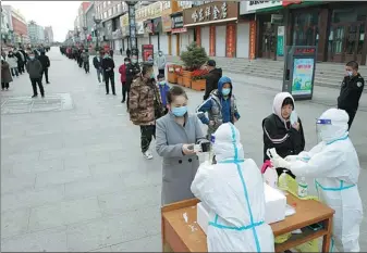  ?? WANG JIANWEI / XINHUA ?? People wait in line for a nucleic acid test for the novel coronaviru­s in Bayan county, Harbin, Heilongjia­ng province, on Saturday.