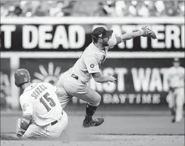  ?? Joe Robbins Getty Images ?? NICK SENZEL of the Cincinnati Reds slides safely at second base as a wild throw by Dodgers shortstop Corey Seager sails past second baseman Chris Taylor in a three-run third inning at Great American Ball Park.