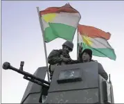  ?? BRAM JANSSEN / ASSOCIATED PRESS ?? Kurdish peshmerga fighters stand on top of a military vehicle Monday as they advance toward villages surroundin­g Mosul. They were 19 miles east of the Islamic State stronghold city in Iraq.