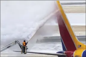  ?? (AP/Omaha World-Herald/Chris Machian) ?? Crews de-ice a Southwest Airlines plane before takeoff Wednesday in Omaha, Neb.