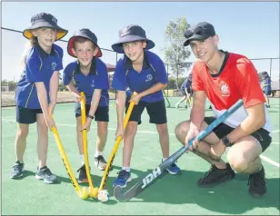  ?? Picture: PAUL CARRACHER ?? DRILLS AND SKILLS:
Hockey Victoria coach Harry Knight takes Horsham Holy Trinity Lutheran College grade-three students, from left, Indi Finn, Liam Rose and Abel Neumann through some beginner drills.