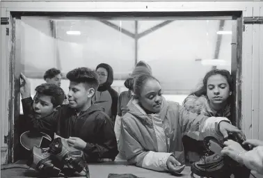  ??  ?? Bennie Dover Jackson Middle School students, from left, Bryan Martinez, Jario Ruiz, Darielis Arnold and Karla Reyes, wait for ice skates before a session of the Learn to Skate program at Connecticu­t College in New London.