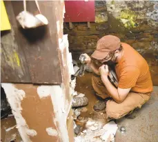  ?? AMY SHORTELL / THE MORNING CALL ?? Timber consultant Michael Cuba examines the summer beam in the basement.